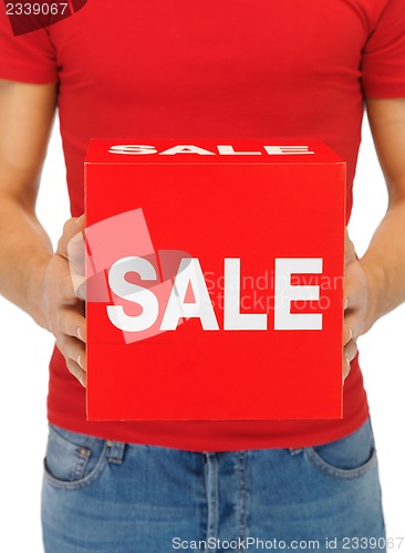 Image of man's hands holding sale sign