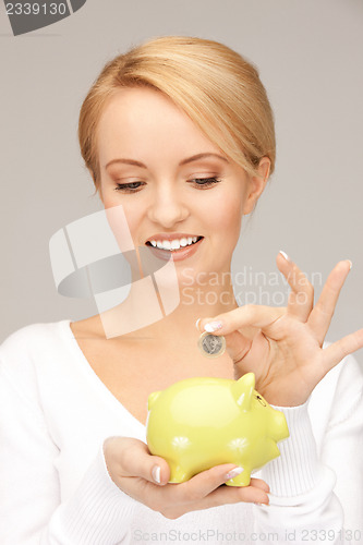 Image of lovely woman with piggy bank and money