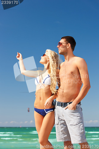 Image of happy couple in sunglasses on the beach