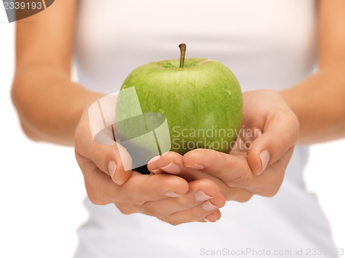 Image of female hands with green apple