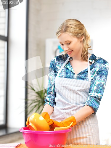 Image of housewife washing dish at the kitchen