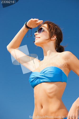 Image of happy woman in sunglasses on the beach