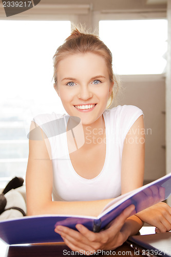 Image of happy and smiling teenage girl with big notepad