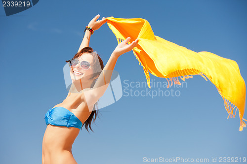 Image of happy woman with yellow sarong on the beach