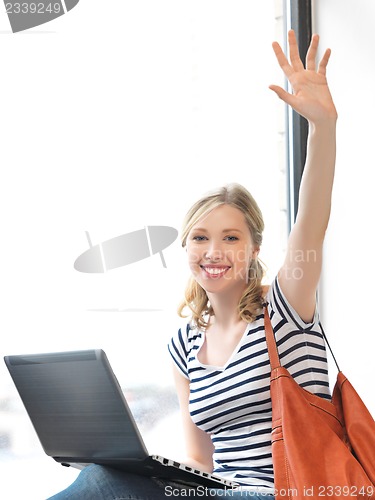 Image of happy teenage girl waving a greeting