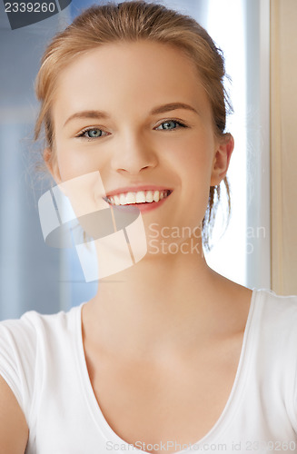Image of happy and smiling teenage girl in a bathroom