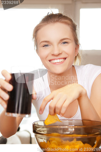 Image of smiling teenage girl with chips and coke
