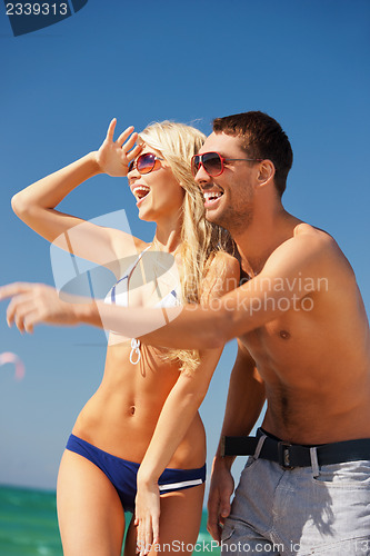 Image of happy couple in sunglasses on the beach