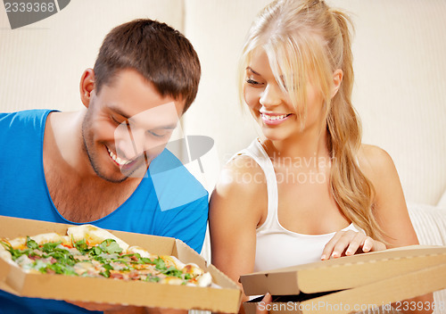 Image of romantic couple eating pizza at home