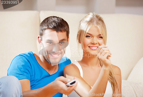 Image of happy romantic couple with TV remote