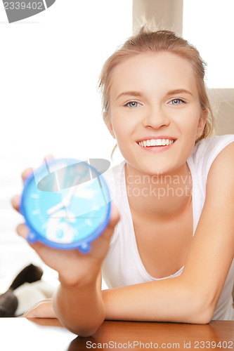 Image of happy and smiling teenage girl with clock