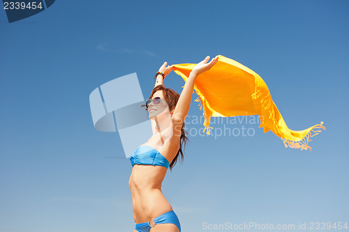 Image of happy woman with yellow sarong on the beach