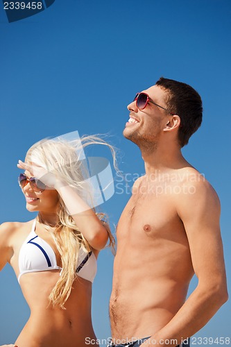 Image of happy couple in sunglasses on the beach