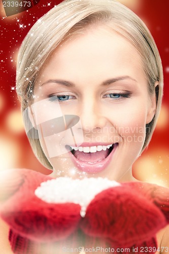 Image of beautiful woman in red mittens with snow