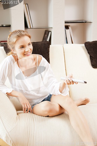 Image of happy teenage girl with TV remote