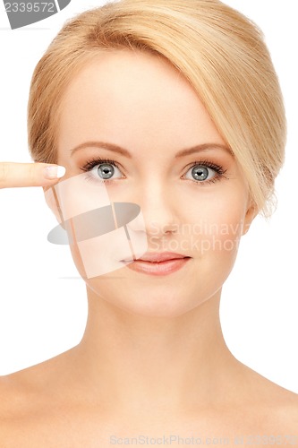 Image of beautiful woman pointing to eye