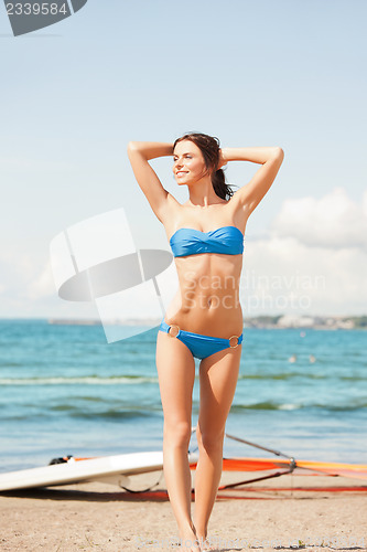 Image of happy woman with wind surf on the beach