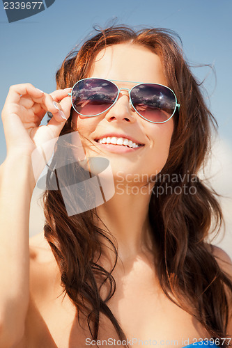 Image of beautiful woman in sunglasses on a beach