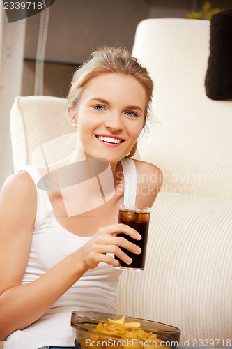 Image of smiling teenage girl with chips and coke