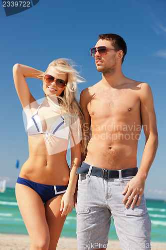 Image of happy couple in sunglasses on the beach