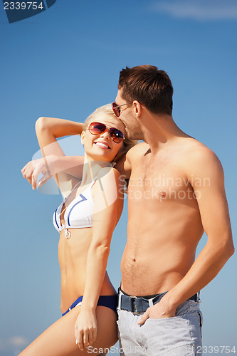 Image of happy couple in sunglasses on the beach