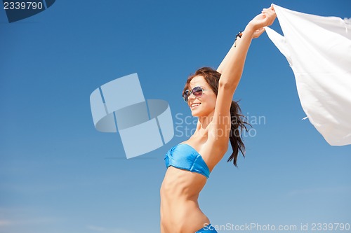 Image of happy woman with white sarong on the beach