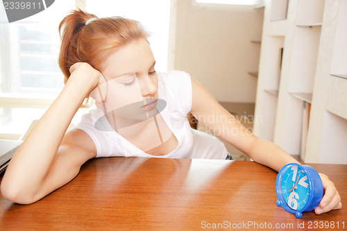 Image of pensive teenage girl with clock