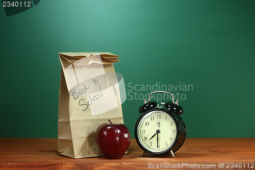 Image of School Lunch, Apple and Clock on Desk at School
