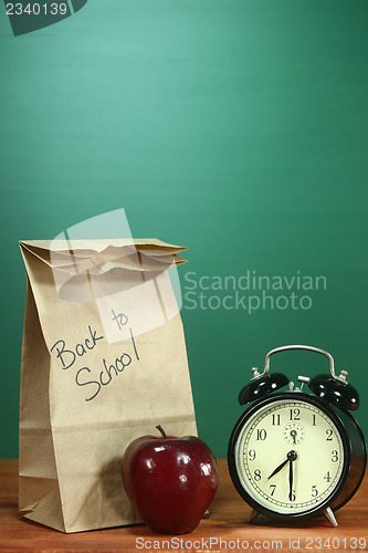 Image of School Lunch, Apple and Clock on Desk at School