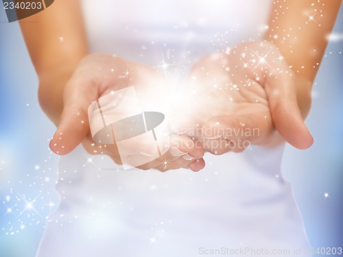 Image of magic twinkles on female hands