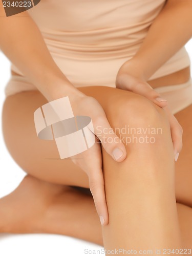 Image of hands touching knee