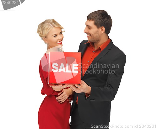 Image of man and woman with sale sign