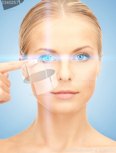 Image of beautiful woman pointing to eye