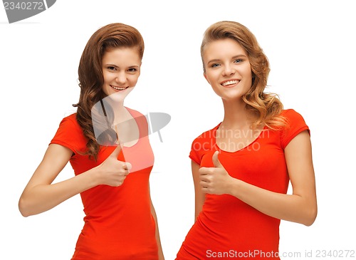 Image of wo teenage girls in red t-shirts showing thumbs up