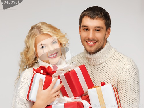 Image of family couple in a sweaters with gift boxes