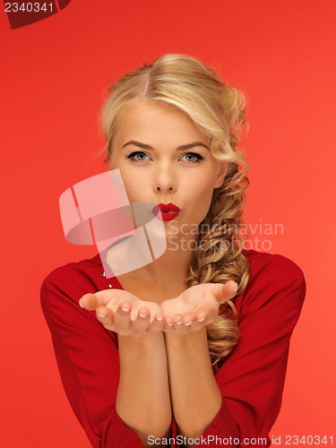 Image of woman blowing something on the palms of her hands