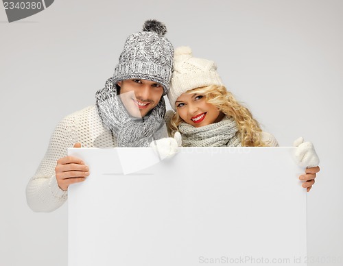 Image of couple in a winter clothes holding blank board