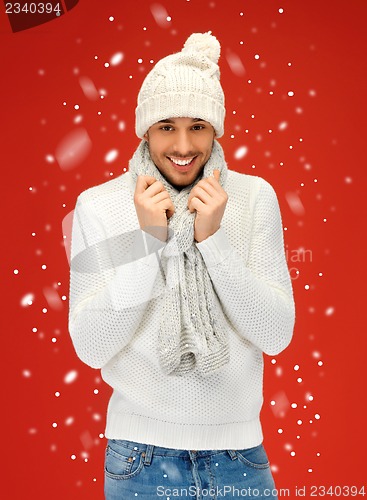 Image of handsome man in warm sweater, hat and scarf