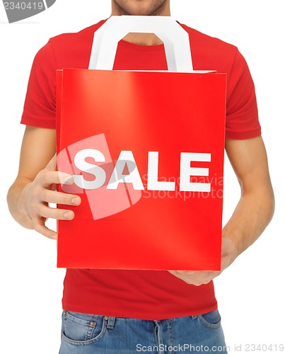 Image of man's hands holding shopping bag