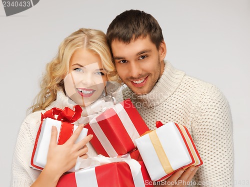 Image of romantic couple in a sweaters with gift boxes