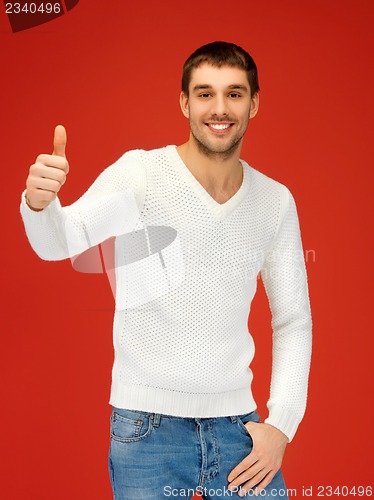 Image of man in warm sweater showing thumbs up