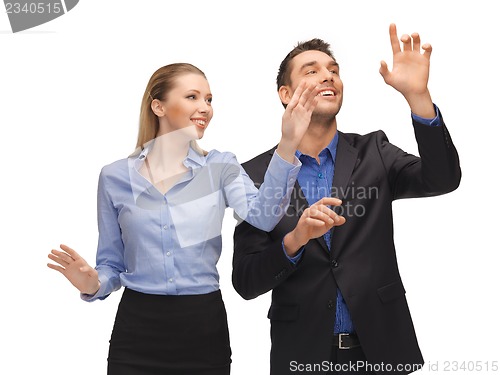 Image of man and woman working with something imaginary