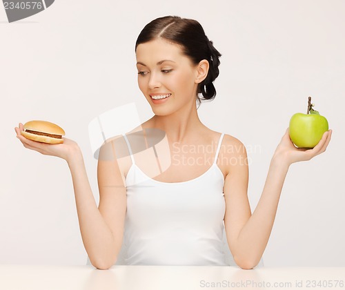 Image of woman with hamburger and apple