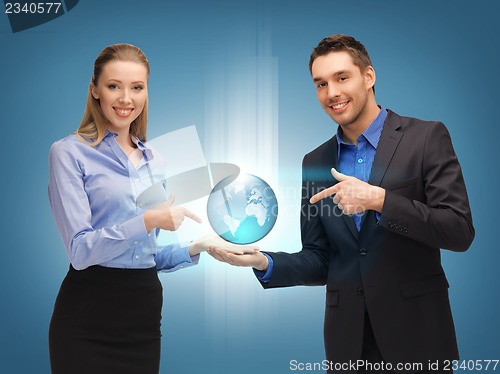Image of man and woman showing earth globe on the palms