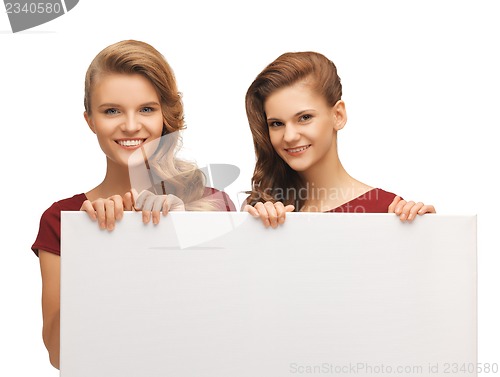 Image of two teenage girls in red dresses with blank board