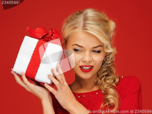 Image of lovely woman in red dress with present