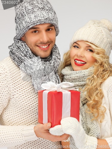 Image of romantic couple in a sweaters with gift box