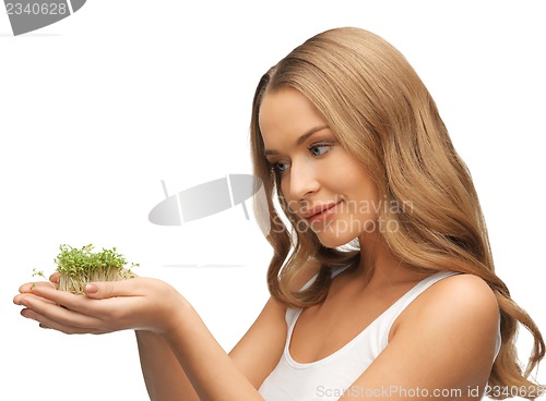 Image of woman with green grass on palms