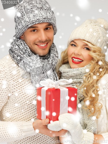 Image of romantic couple in a sweaters with gift box