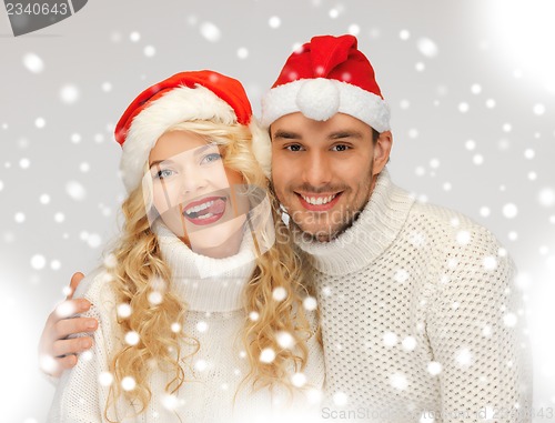 Image of family couple in sweaters and santa's hats